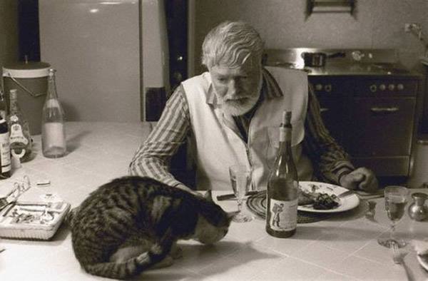 Эрнест Хэмингуэй и кот за столом